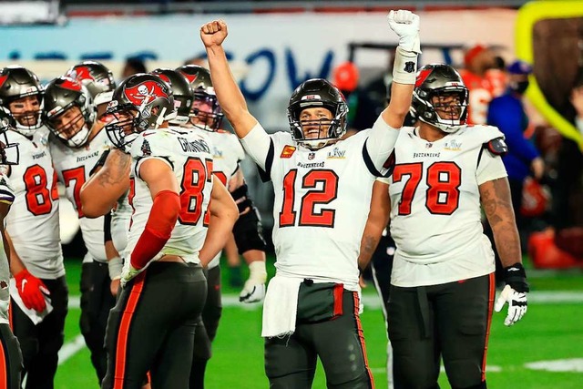 Tom Brady mit der #12 und sein Team feiern den 31:9-Sieg.  | Foto: Mike Ehrmann (AFP)