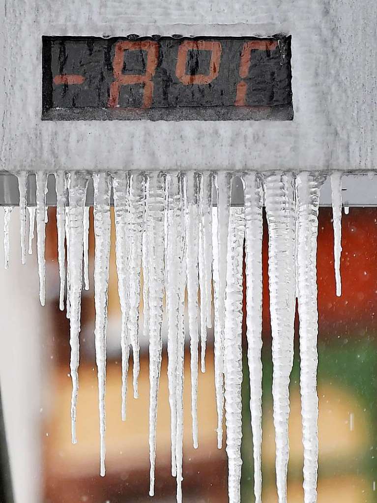 Thringen, Erfurt: Eiszapfen hngen an einer Thermometeranzeige, auf der man Minus acht Grad Celsius lesen kann.