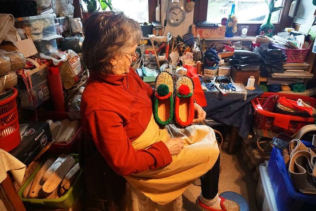 Monika Schultis in ihrer Werkstatt: . ...#8220; die rot-grnen Strohschuhe her.  | Foto: Helmut Hringer