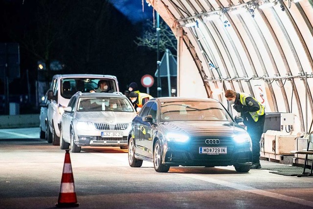 Bundespolizisten kontrollieren an der Grenze aus Tirol kommende Autos.  | Foto: Matthias Balk (dpa)