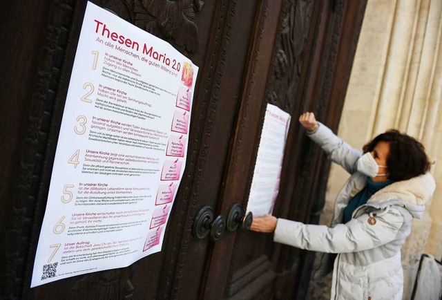 Die Aktivistin Renate Spanning hngt e...n an das Hauptportal der Frauenkirche.  | Foto: Angelika Warmuth (dpa)