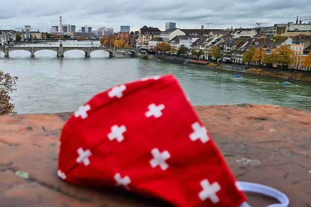 Ein Mund- Nasenschutz mit Schweizerkre...ttleren Rheinbrcke in Basel zu sehen.  | Foto: Stefan Ammann