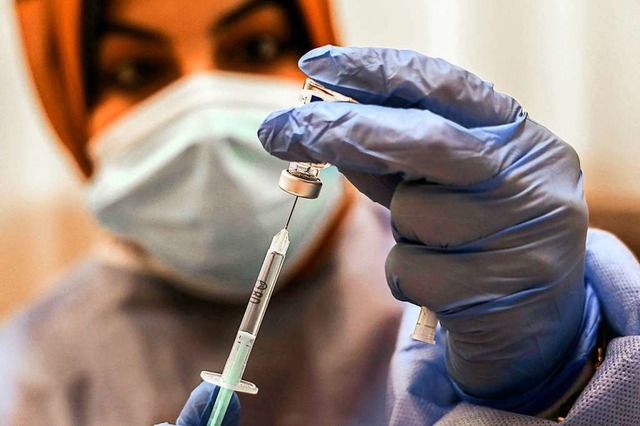 Eine Frau bereitet eine Impfung gegen Covid-19  vor.  | Foto: MOHAMMED ABED (AFP)