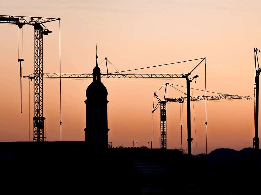 In die Hhe ragen Baukrne und der Kirchturm in Oberhausen. Die Silhouette fotografierte Emanuel Jauch.