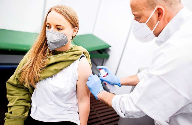 Eine junge Frau erhlt eine Corona-Schutzimpfung.  | Foto: Hauke-Christian Dittrich (dpa)