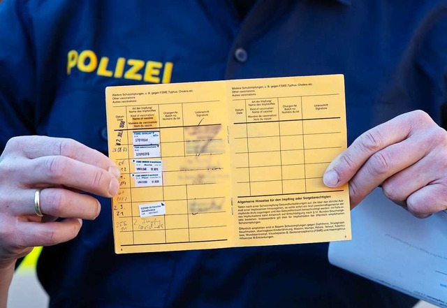 Begehrter Stempel: Ein Polizist hlt d...es Probleme bei der Impfterminvergabe.  | Foto: Sven Hoppe (dpa)