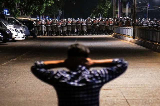 Zwei Lager stehen sich unvershnlich g...ant  einer Reihe  Polizisten entgegen.  | Foto: Theint Mon Soe (dpa)