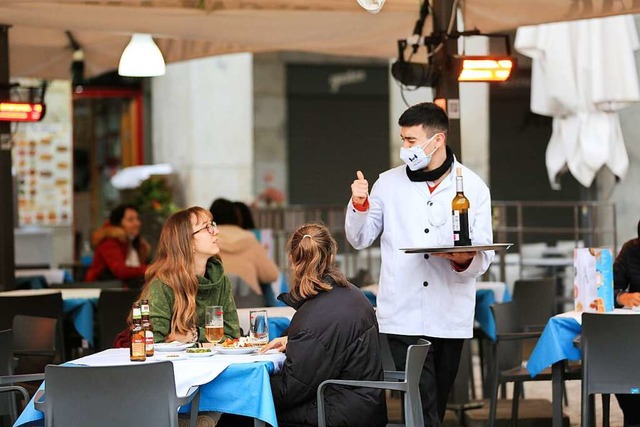 Ein Kellner bedient zwei Kundinnen auf...rasse einer Bar im Zentrum von Madrid.  | Foto: Tamara Rozas (dpa)