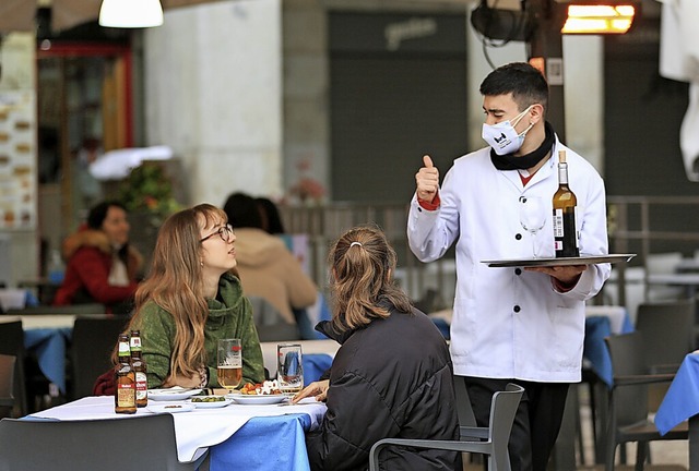 Ein Kellner bedient zwei Kundinnen auf...rasse einer Bar im Zentrum von Madrid.  | Foto: Tamara Rozas (dpa)