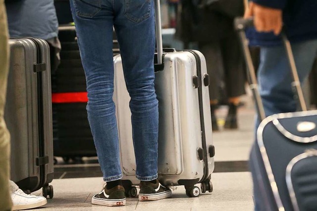 Passagiere stehen mit ihren Reise-Koff...g nach Palma de Mallorca einzuchecken.  | Foto: David Young (dpa)