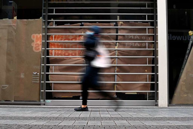 Eine Passantin vor einem geschlossenen...ere Lockerungsschritte gemacht werden.  | Foto: INA FASSBENDER (AFP)