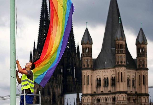 Mit dem Aufhngen der Regenbogenfahne ...schlechtlicher Beziehungen ffentlich.  | Foto: Oliver Berg (dpa)