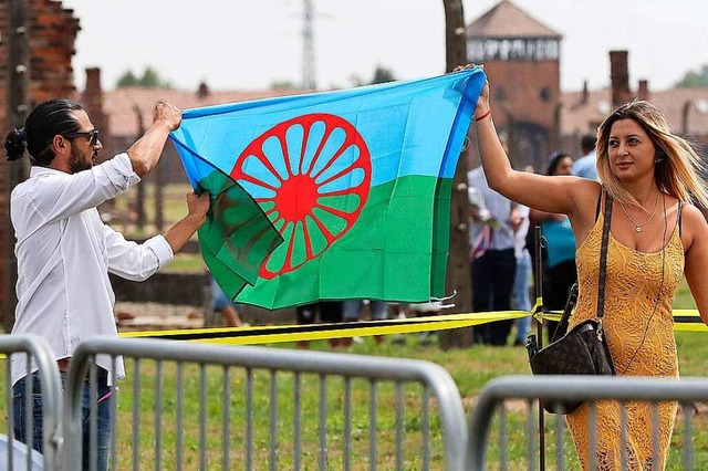 Zwei Besucher des ehemaligen Vernichtu... Roma eine Roma-Fahne in ihren Hnden.  | Foto: Czarek Sokolowski (dpa)