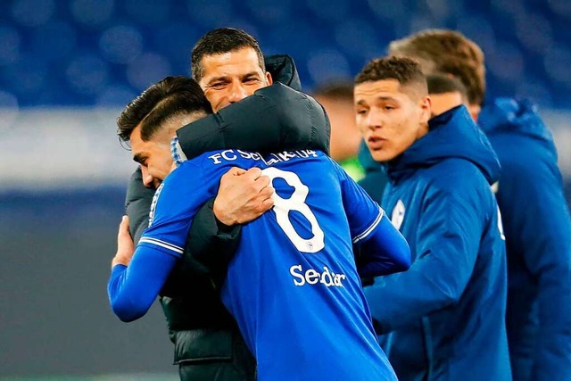 Schalke-Trainer Dimitrios Grammozis umarmt Mittelfeldspieler Suat Serdar.  | Foto: LEON KUEGELER (AFP)