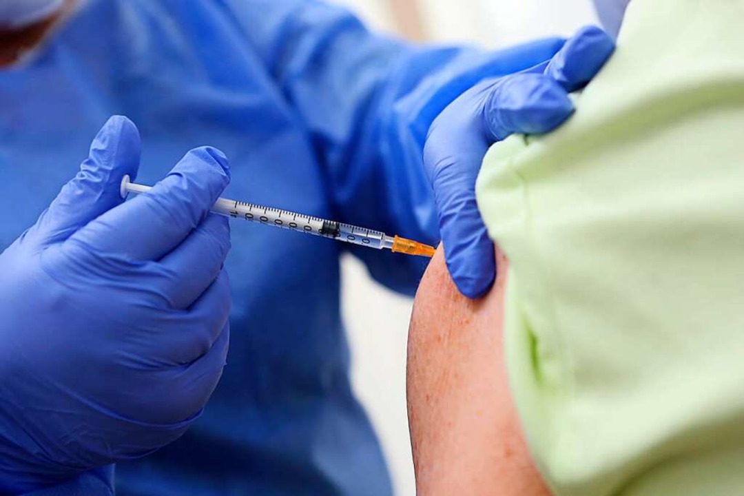Eine achtzigjährige wird in einem Impfzentrum geimpft.  | Foto: Matthias Bein (dpa)