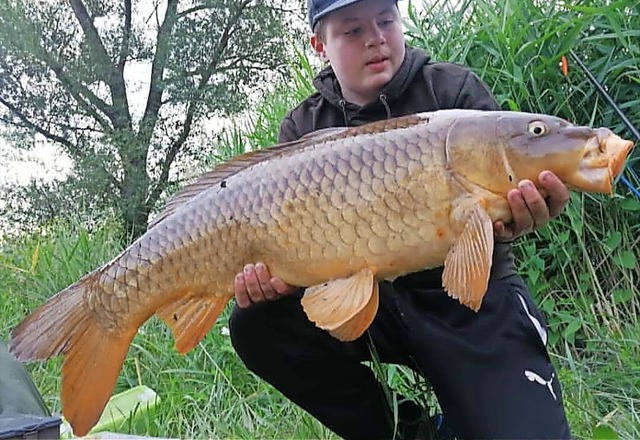 Jonas mit einem Karpfen, den er aus dem Wasser gefischt hat.   | Foto: privat