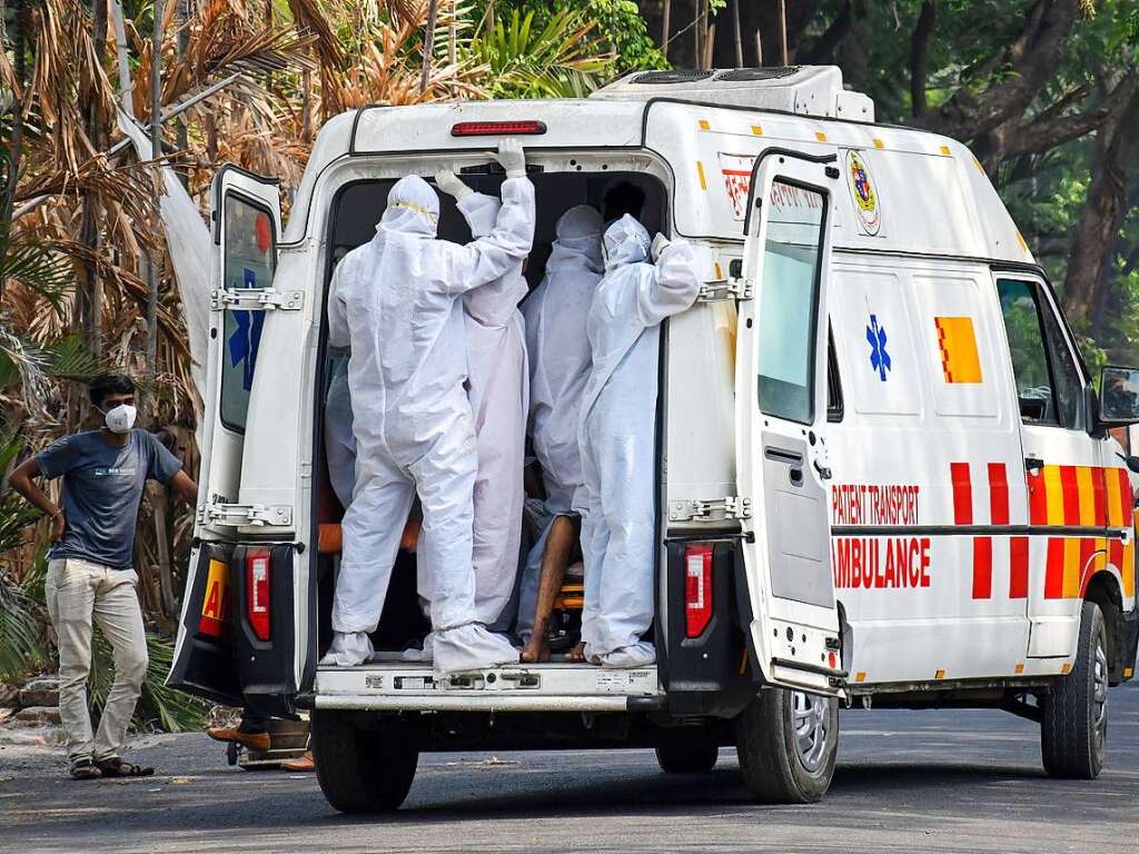 Rettungskrfte transportieren einen Covid-19-Patienten in einem Krankenwagen in ein Krankenhaus in Mumbai.