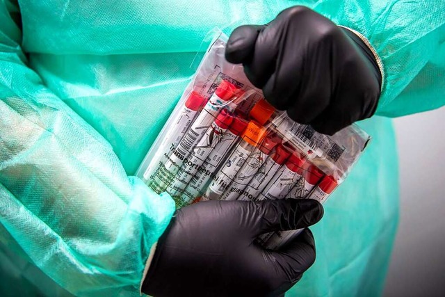 Proben fr einen PCR-Test werden von e... in einem Corona-Testzentrum verpackt.  | Foto: Sina Schuldt (dpa)