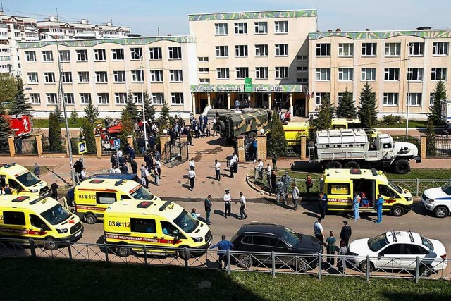 Krankenwagen und Polizeiautos sowie ei...lf Todesopfern in der Grostadt Kasan.  | Foto: Roman Kruchinin (dpa)