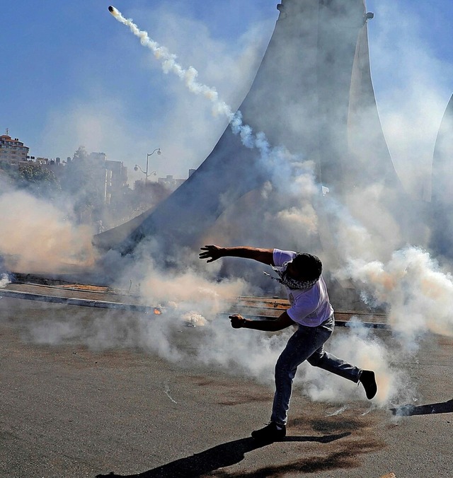 Ein palstinensischer Demonstrant wirf...bgeschossene Trnengasbehlter zurck.  | Foto: ABBAS MOMANI (AFP)