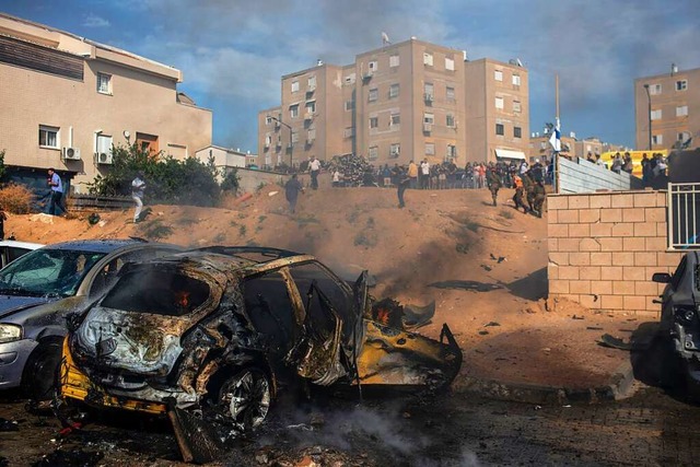 Eine aus dem Gazastreifen abgefeuerte ...e Autos auf einem Parkplatz in Israel.  | Foto: Ilia Yefimovich (dpa)