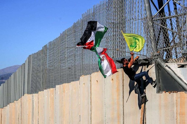 Ein Hisbollah-Anhnger am Grenzzaun zwischen Israel und Libanon  | Foto: Marwan Naamani (dpa)