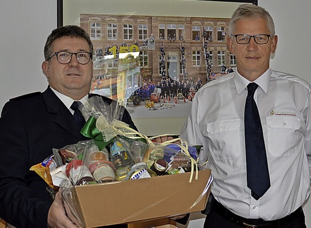 Reiner Jacob (links) berreicht seinem Vorgnger Gnter Lenke einen Prsentkorb.  | Foto: Feuerwehr Lrrach