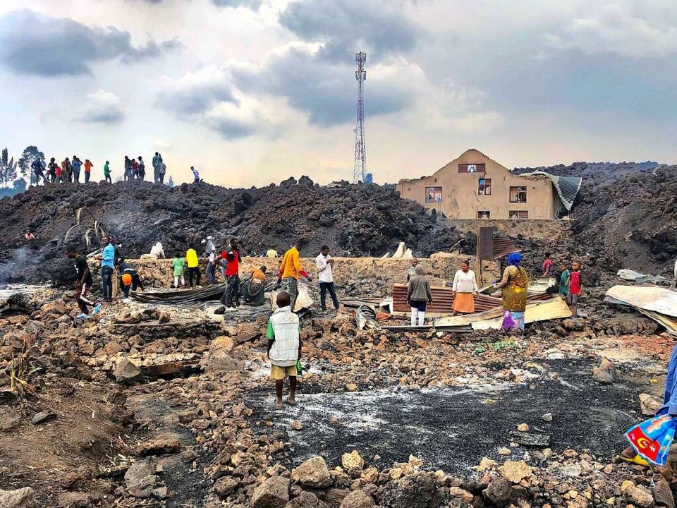Menschen versammeln sich an einem Stro...Ausbruch des Mount Nyiragongo in Goma.  | Foto: Clarice Butsapu (dpa)