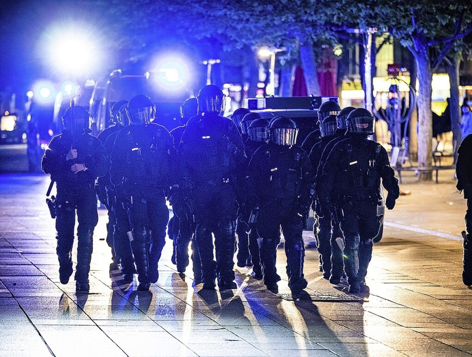 Einsatzkräfte der Polizei laufen am Samstagabend durch die Königsstraße.  | Foto: Christoph Schmidt (dpa)