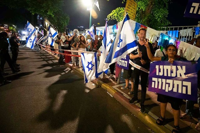 Israelische Demonstranten rufen Slogan...ie Bildung einer neuen Regierung hoch.  | Foto: Sebastian Scheiner (dpa)