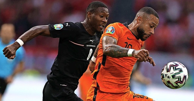 Torschtze Memphis Depay (rechts) im Z...hen Elfmeter-Verursacher  David Alaba   | Foto: DEAN MOUHTAROPOULOS (AFP)