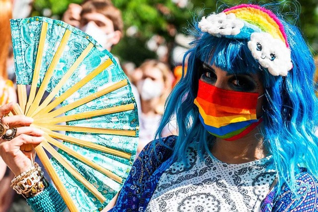 Ein Teilnehmer der CSD Berlin Pride ... Regenbogenfarbenen Mund-Nasen-Schutz.  | Foto: Christophe Gateau (dpa)