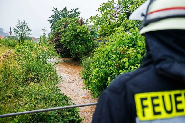 Ein Feuerwehrmann berprft den Pegelstand an einem Hochwasser fhrenden Bach.  | Foto: Philipp von Ditfurth (dpa)