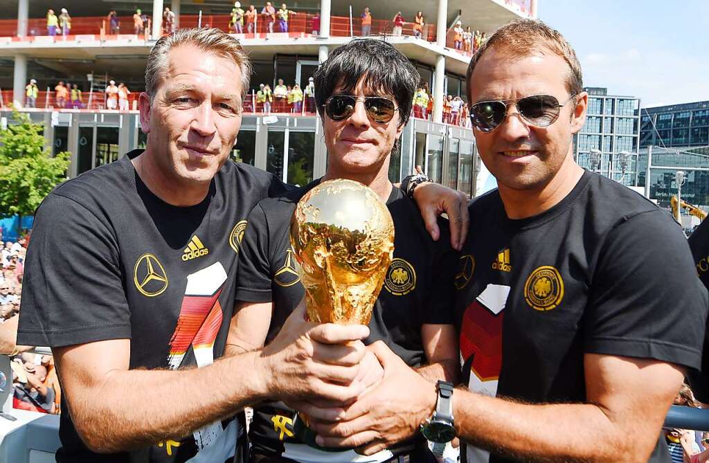 Der WM-Titel 2014 und der Moment des grten Triumphes. Mit Sonnenbrille und Dauergrinsen prsentiert Lw (Bildmitte) den WM-Pokal. Rechts im Bild sein damaliger Co-Trainer und jetziger Nachfolger Hansi Flick.