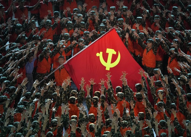 Als Rettungskrfte verkleidete Darstel...eine Fahne der Kommunistischen Partei.  | Foto: Ng Han Guan