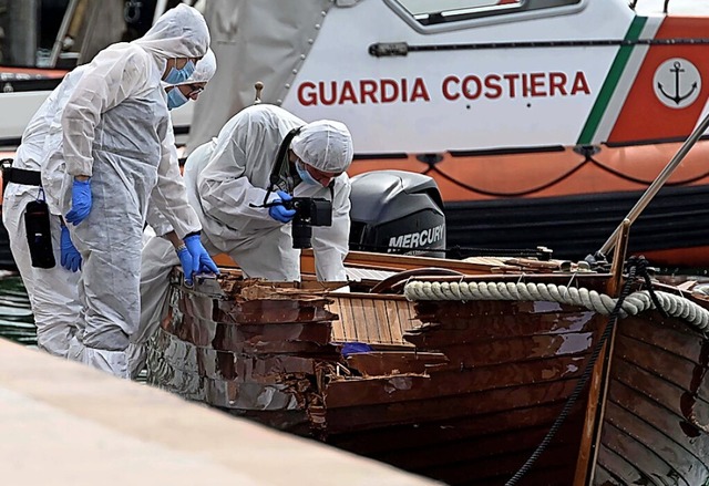 Forensiker untersuchen das beschdigte Boot.  | Foto: Gabriele Strada (dpa)