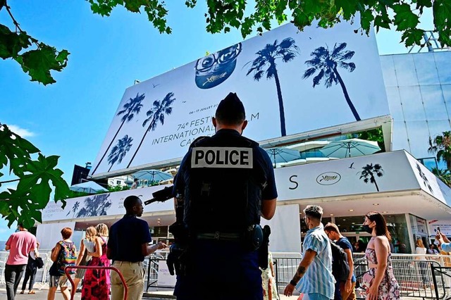 Im verschrften Sicherheitsmodus: ein ...und Passanten vor dem Palais in Cannes  | Foto: JOHN MACDOUGALL (AFP)