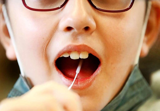 Eine Schlerin macht den Lolli-Test.  | Foto: Roland Weihrauch (dpa)