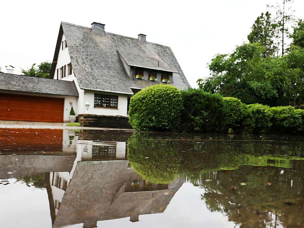 Wasser steht im Ortsteil Kleineichen vor einem Haus auf der Strae. Nach massiven Regenfllen muten etwa 1500 Menschen in Hckeswagen im Bergischen Land ihre Wohnungen verlassen. Betroffen war vor allem der Stadtteil Kleineichen unterhalb der Bevertalsperre.