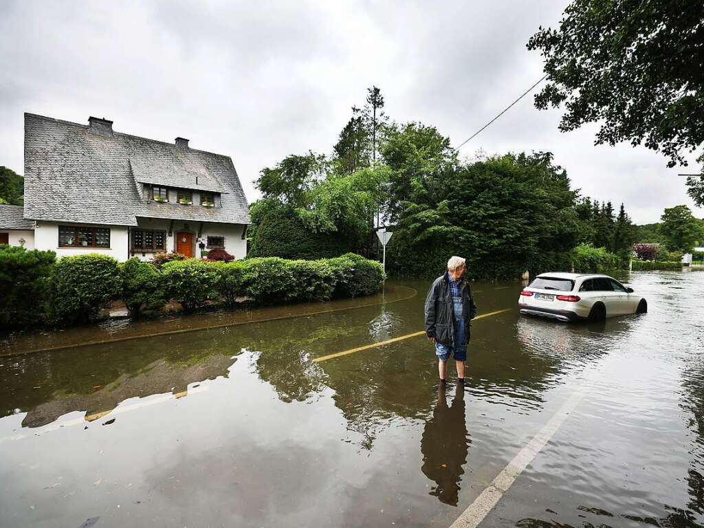 Hans-Gert Schmitz steht im Hochwasser an seinem Auto, das steckengeblieben ist. Nach massiven Regenfllen muten etwa 1500 Menschen in Hckeswagen im Bergischen Land ihre Wohnungen verlassen.