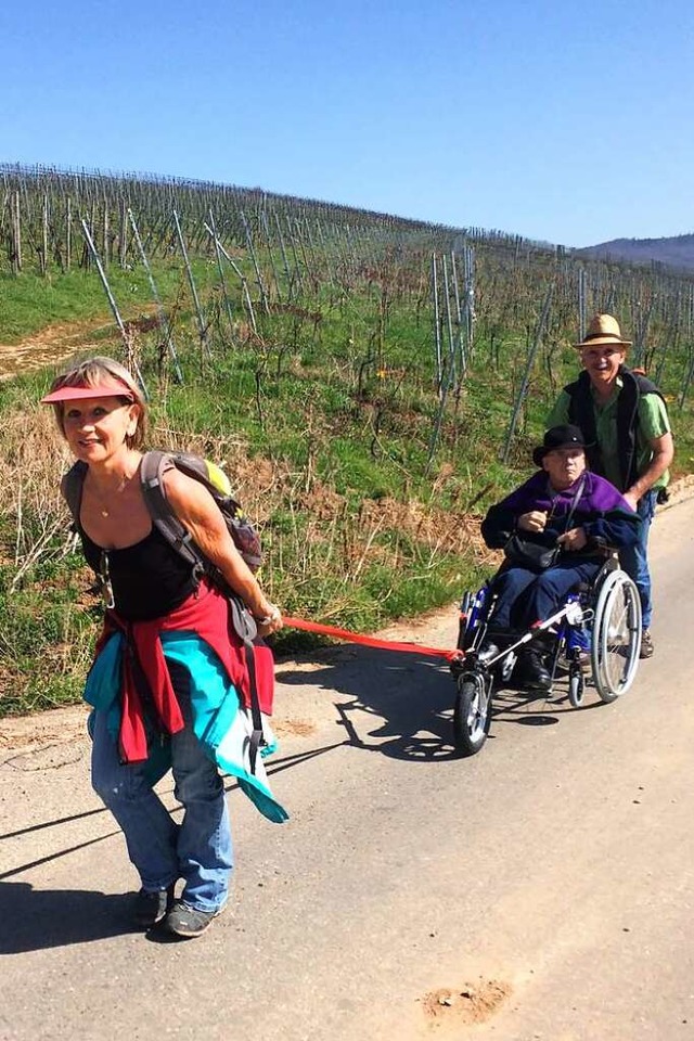 Gabriele Hartmann zieht einen Rollstuhlfahrer den Batzenberg hoch.  | Foto: Michael Fritz