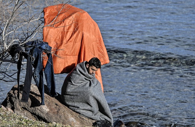 Ein afghanischer Flchtling hat mit an... darauf, dass seine Kleider trocknen.   | Foto: LOUISA GOULIAMAKI