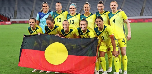 Die australischen Fuballerinnen posie...seeland mit der Flagge der Aborigines.  | Foto: YOSHIKAZU TSUNO (AFP)