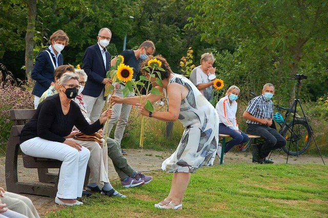 Dorothea Flaig verteilt Sonnenblumen a...links hinten Landrtin Marion Dammann.  | Foto: Petra Wunderle