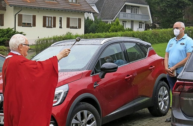 Pfarrer Horst Herz segnet und besprengt die Autos mit Weihwasser.  | Foto: Erhard Morath