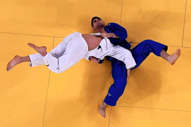 Lascha Bekauri (in Wei) aus Georgien ...tschen Judoka Eduard Trippel gewonnen.  | Foto: ANTONIN THUILLIER (AFP)