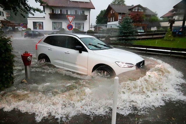 Ein Auto fhrt durch das hoch stehende Wasser auf einer Strae im Oberallgu.  | Foto: Davor Knappmeyer (dpa)
