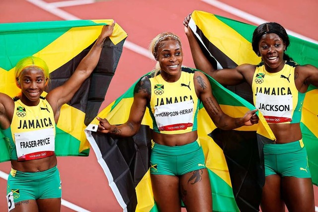 Jamaikas Zweitplatzierte Shelly-Ann Fr...n.r.) feiern mit Fahnen ihren Triumph.  | Foto: Oliver Weiken (dpa)
