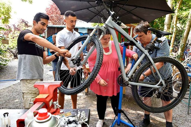 In der Fahrradwerkstatt gibt Peter Rie... Amar Khatib(von links) packen mit an.  | Foto: Thomas Kunz