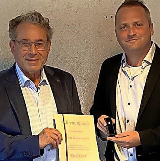 Vorsitzender Gerrit Hveler (rechts) ...z Zimmermann Urkunde und Anstecknadel.  | Foto: Privat
